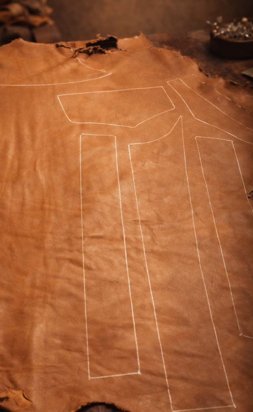 Brown leather with white sewing lines on a dark background
